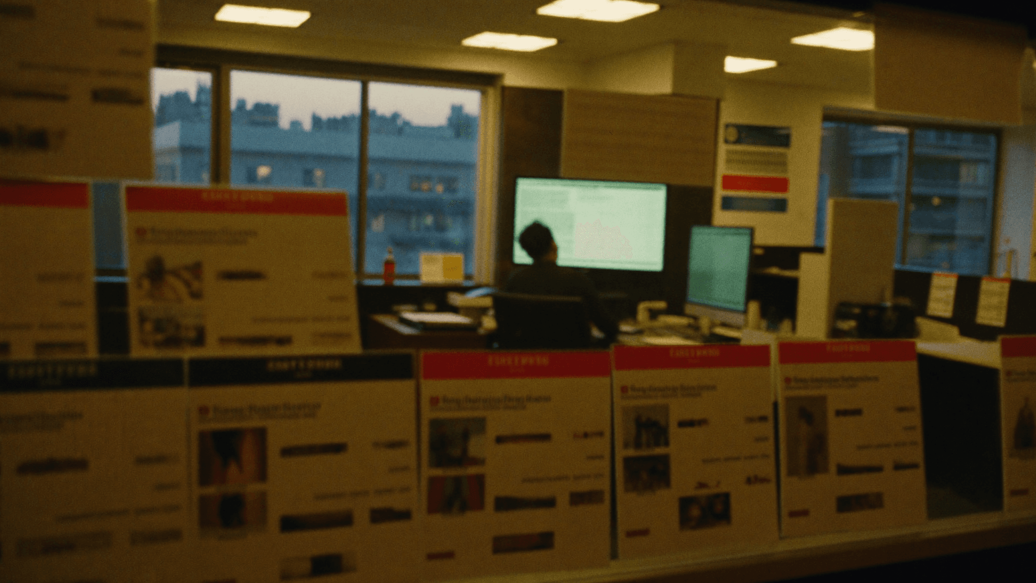 Property agent reviewing listings at a UK high-street lettings agency office at dusk