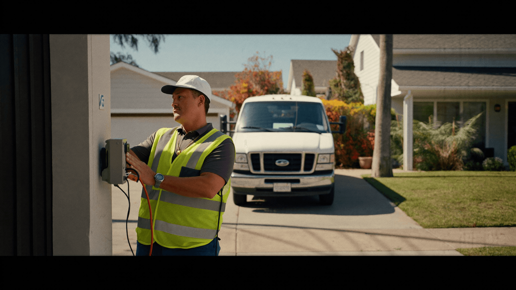Australian electrician in hi-vis testing a residential switchboard outside a suburban Sydney home