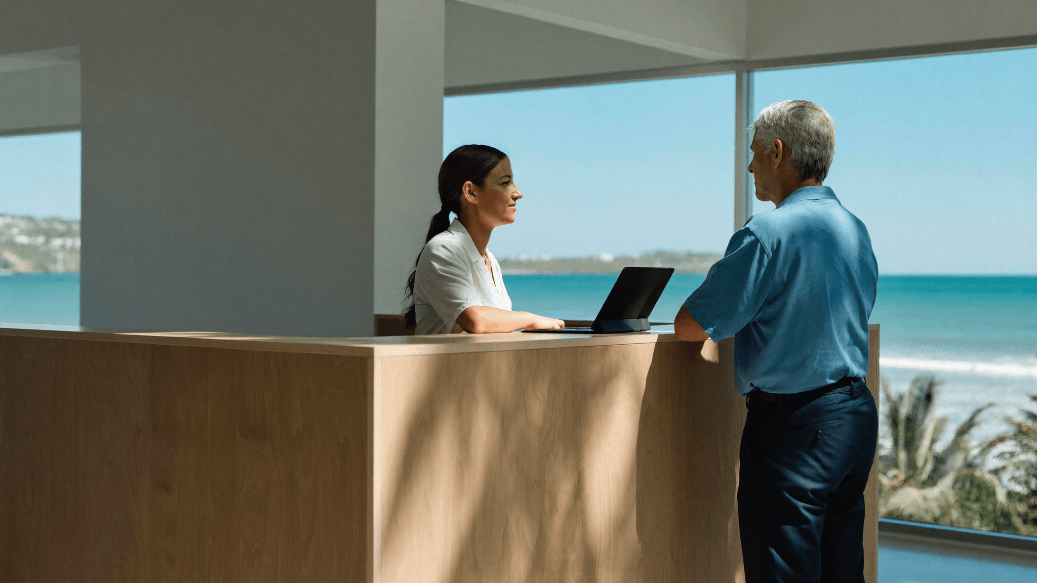 Receptionist welcoming a patient at a bright modern coastal dental clinic on the Gold Coast