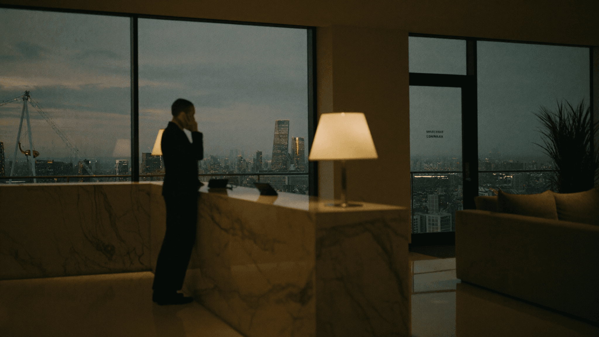 Receptionist taking a call at an elegant London office front desk with the City skyline behind