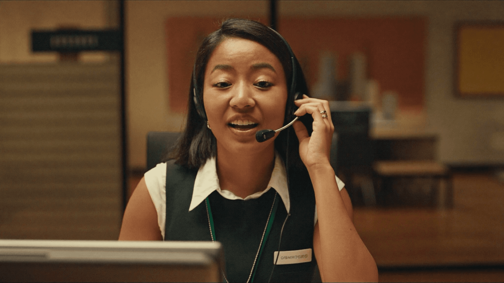 Receptionist with a headset warmly handling a client call at a modern front desk