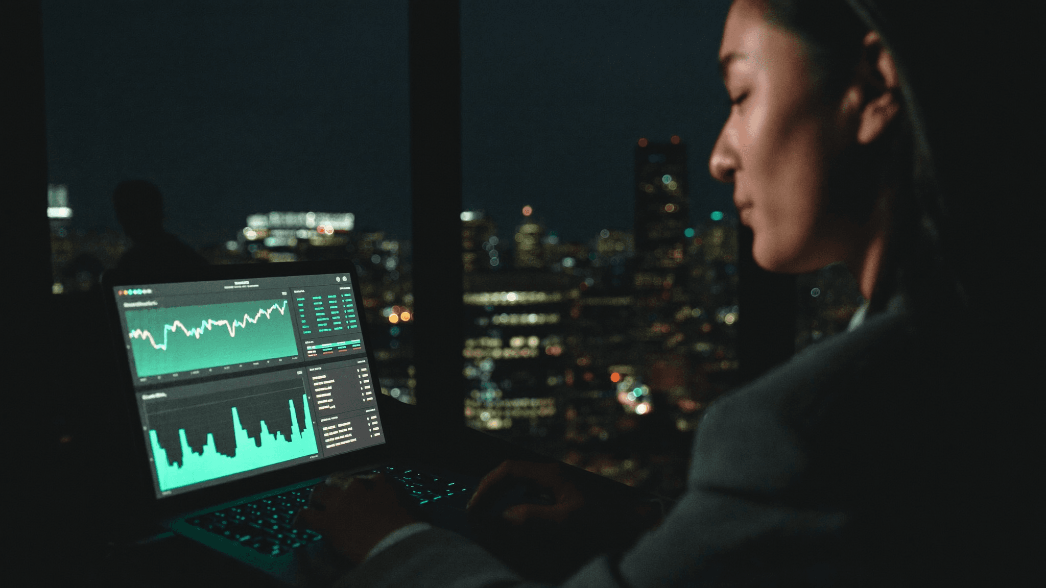 Business owner reviewing automated operations on a laptop in a dark modern office